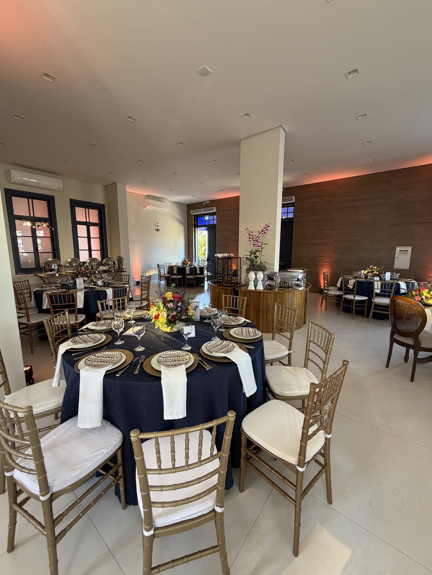 Salão principal montado com mesas redondas e cadeiras Tiffany