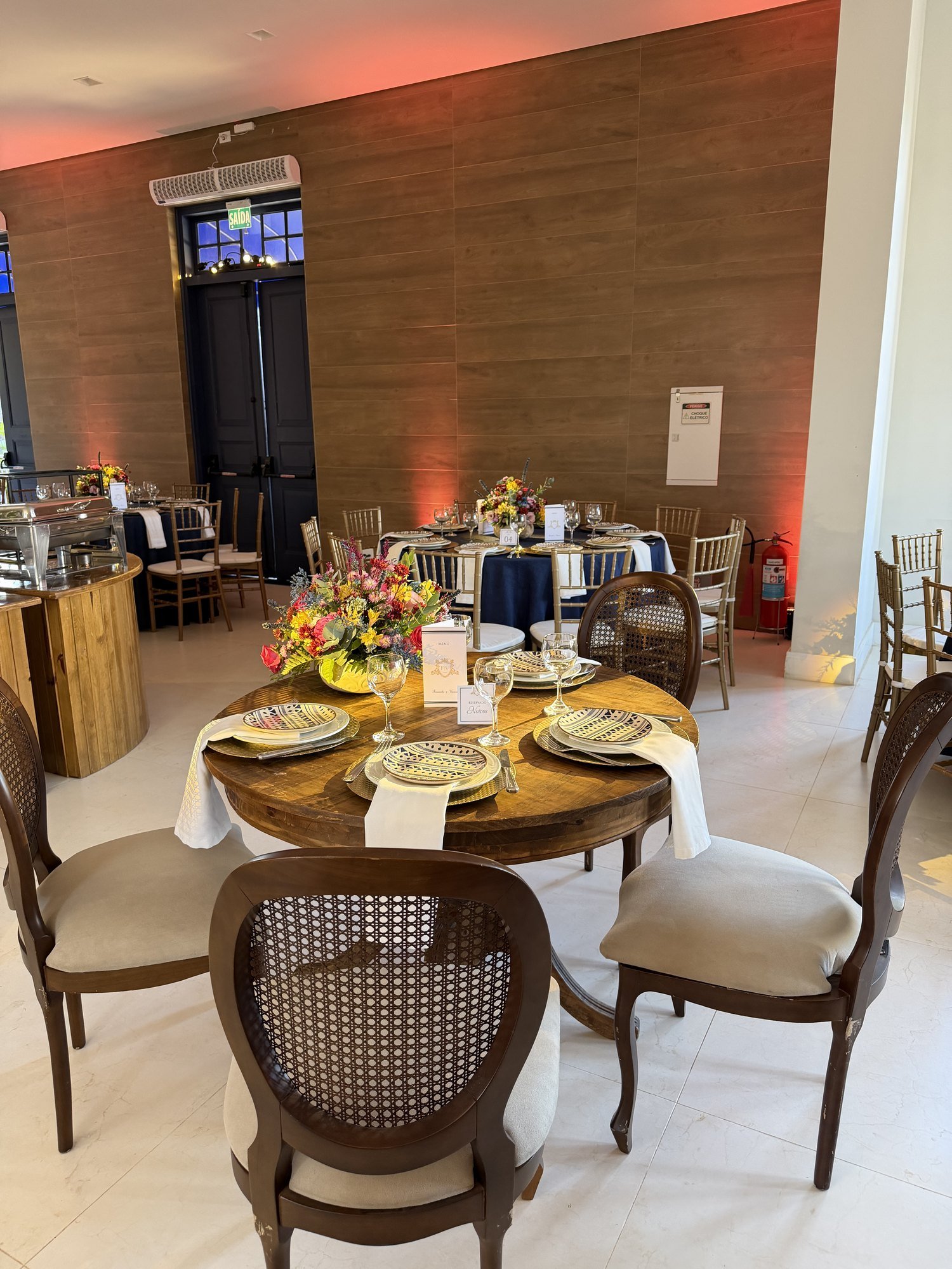 Mesa redonda posta com flores coloridas e louça elegante